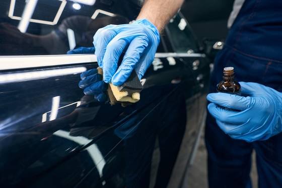 Aplicação de camada de proteção sobre a pintura de um carro com aplicador