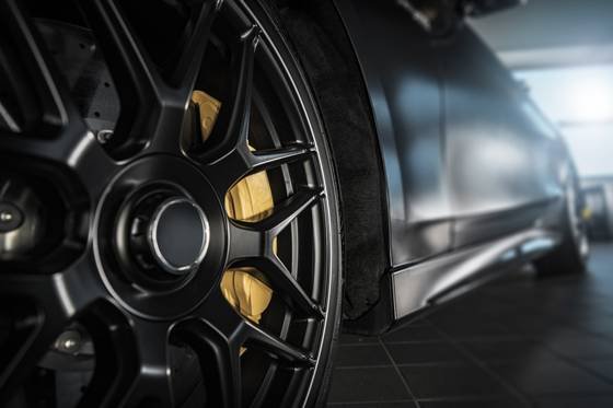Roda de liga leve de um carro escuro, vista de perto na oficina